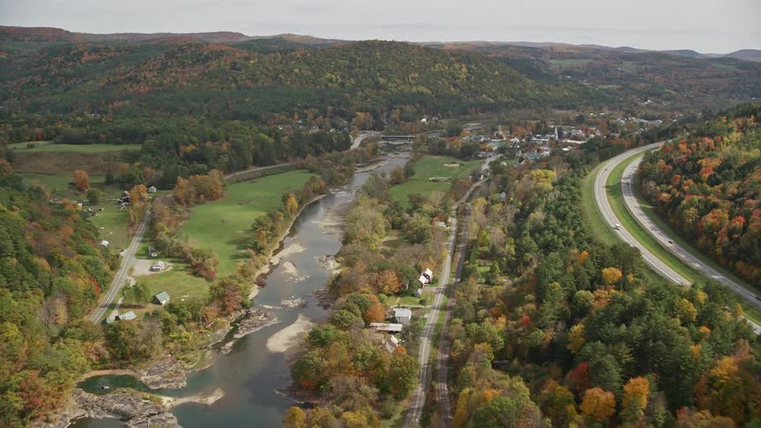 A rural region with a road and a river with several trees around it