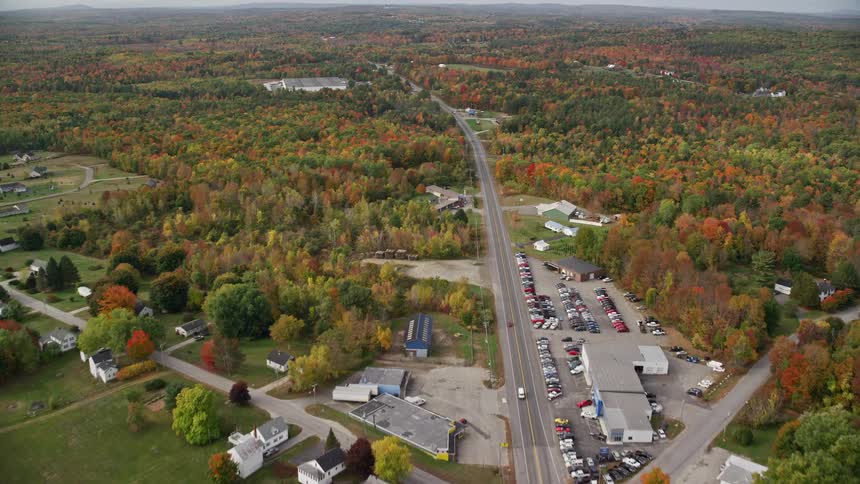 A rural region with some houses and several forests on the sides