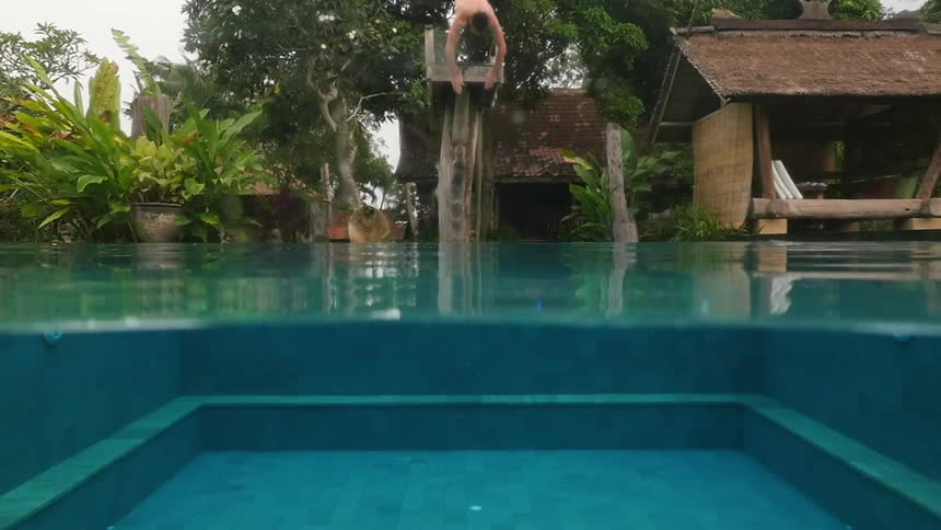 A man jumping off a diving board into a pool