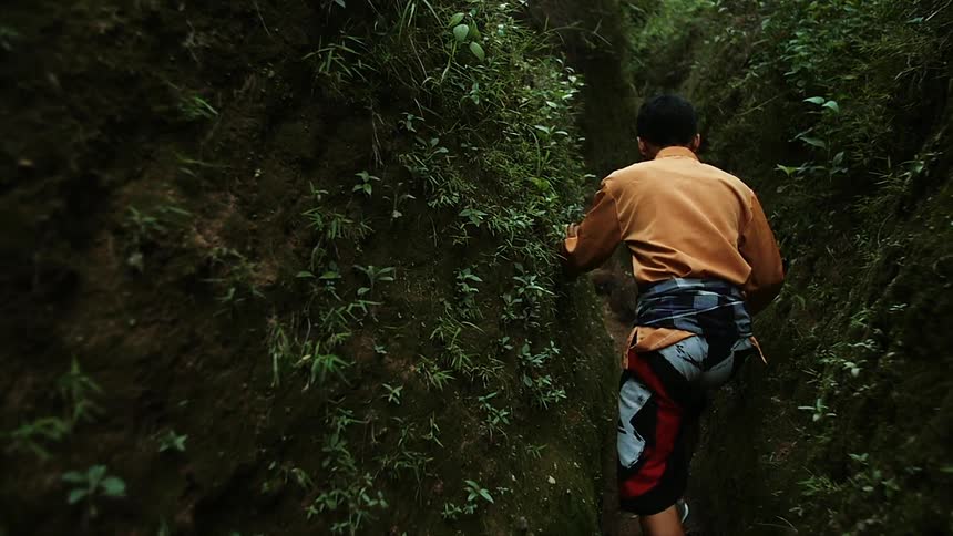 A man hiking in a narrow mountain path