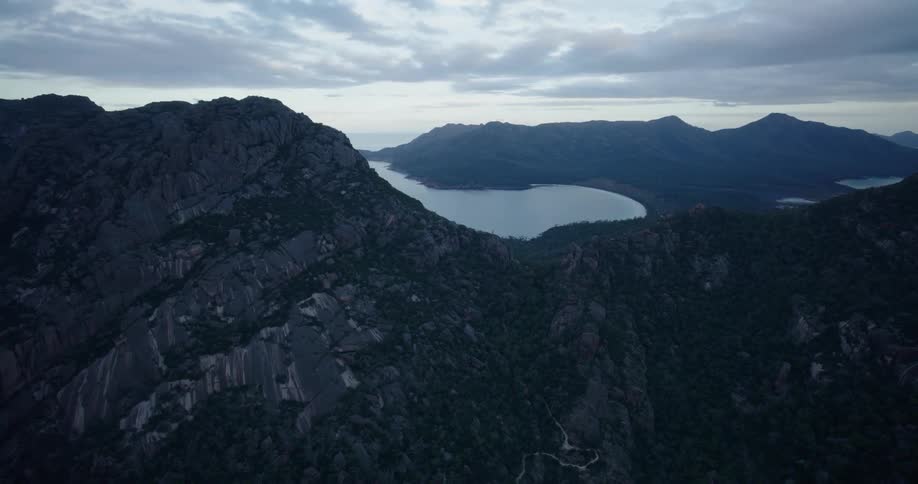 An aerial view of a rocky mountain ridge with the sea in the background