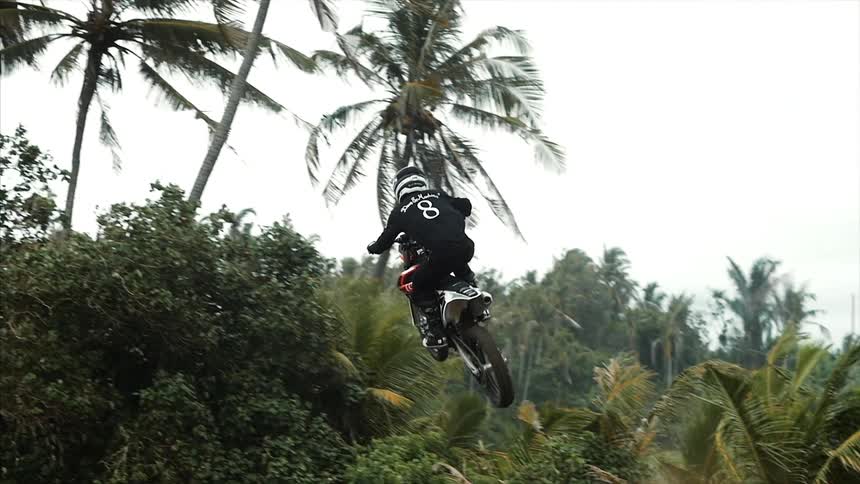 A person going up a ramp and flying through the air on a dirt bike