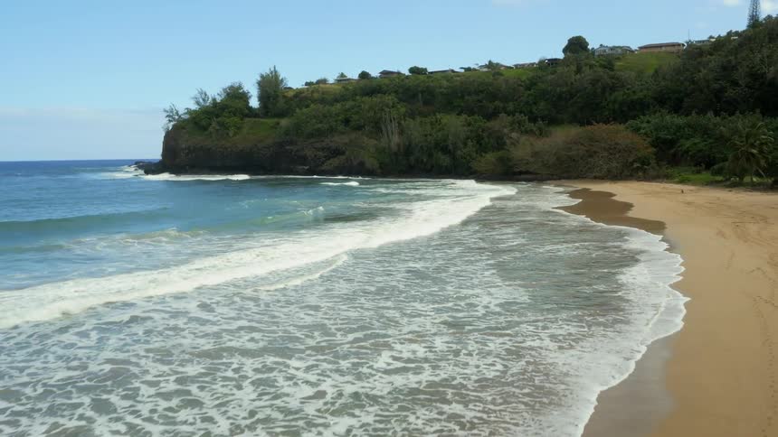 A beach with waves coming into shore on a clear sunny day