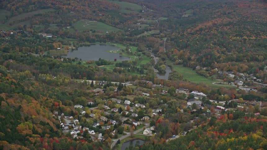A rural area with many houses amidst many forest trees