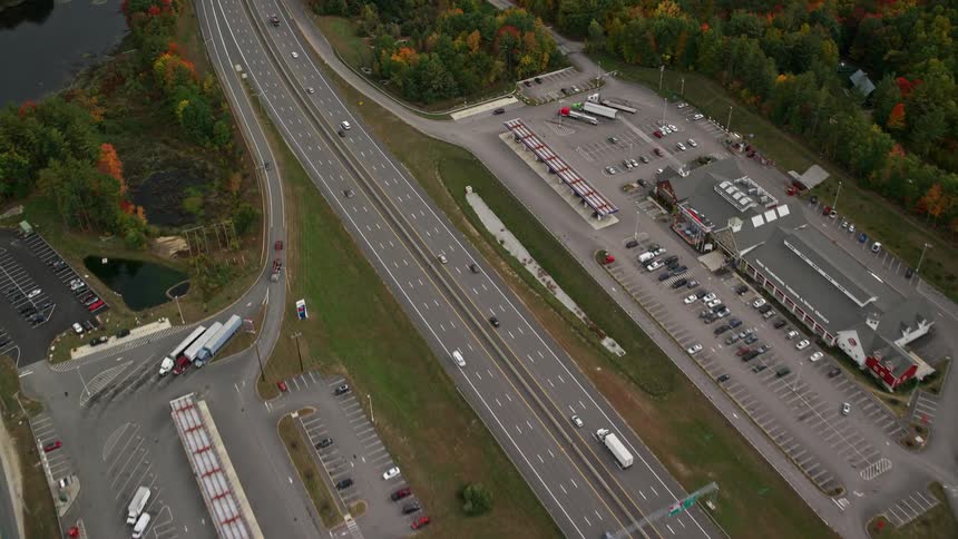 Aerial of the highway near an urban neighborhood surrounded by forest