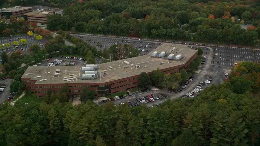 Fall woods surround office buildings and nearby houses
