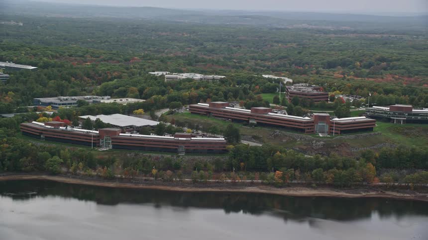 Brown colored long buildings with trees at waterfront at midday