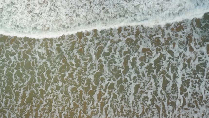 Waves crash against the shore below