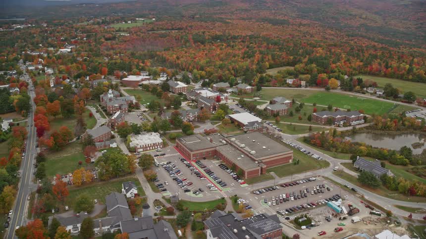 An aerial view of a small urban town surrounded by a vast forest