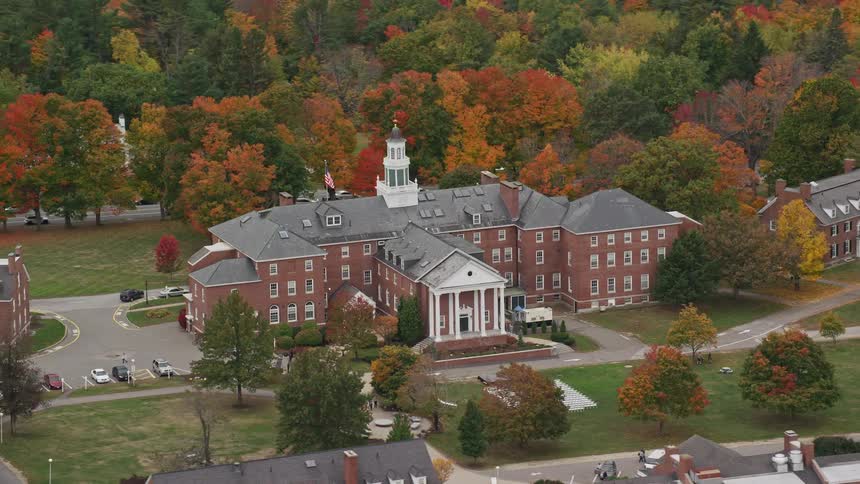 A campus building in a sub urban area surrounded by trees