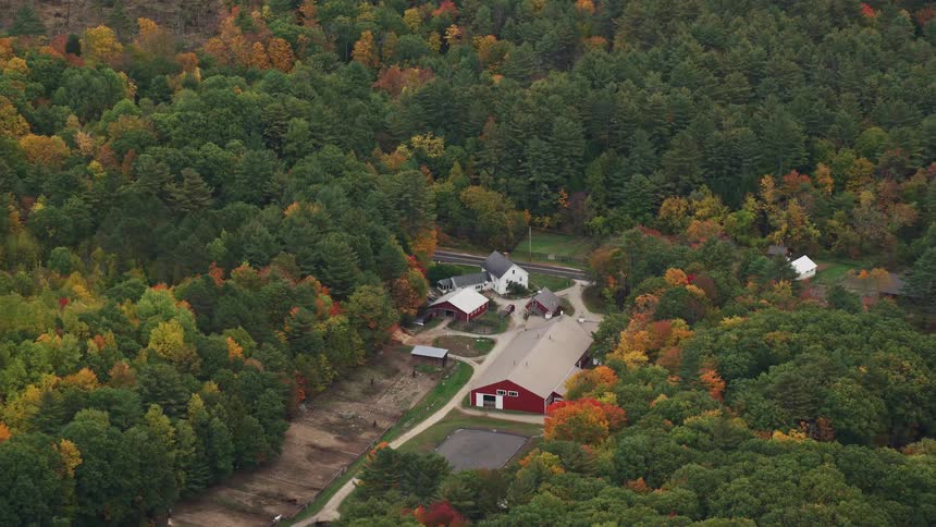 Aerial view red barn in rural landscape in fall colors