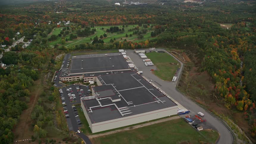 Aerial view of multitenant industrial facility and autumn forest