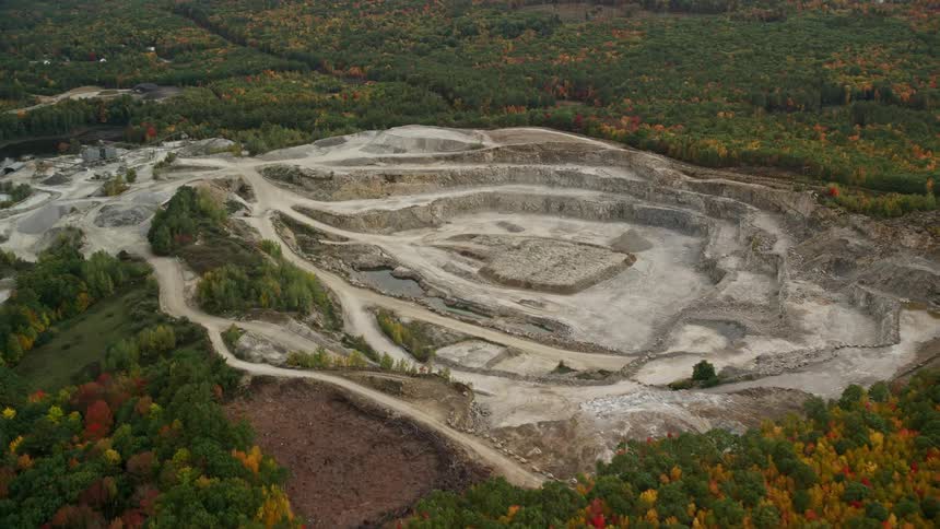 Aerial view of a mine quarry and highway near the forest