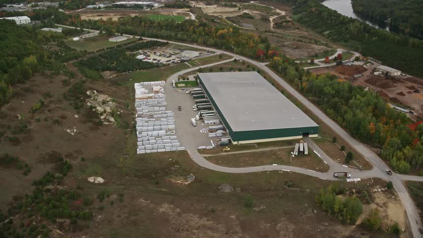 A warehouse with trucks parked outside ready for distribution