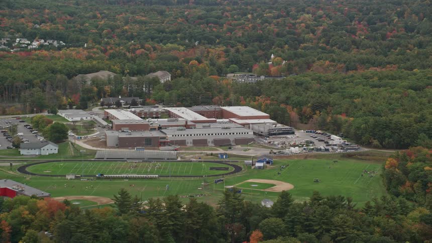 A large wide building with many trees around it