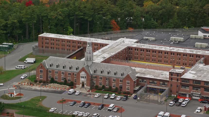 A commercial building with a tower on top and some cars parked in front