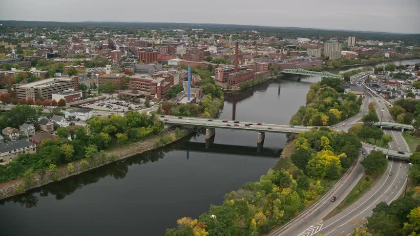 Aerial view of bridge over river and buildings on fall day