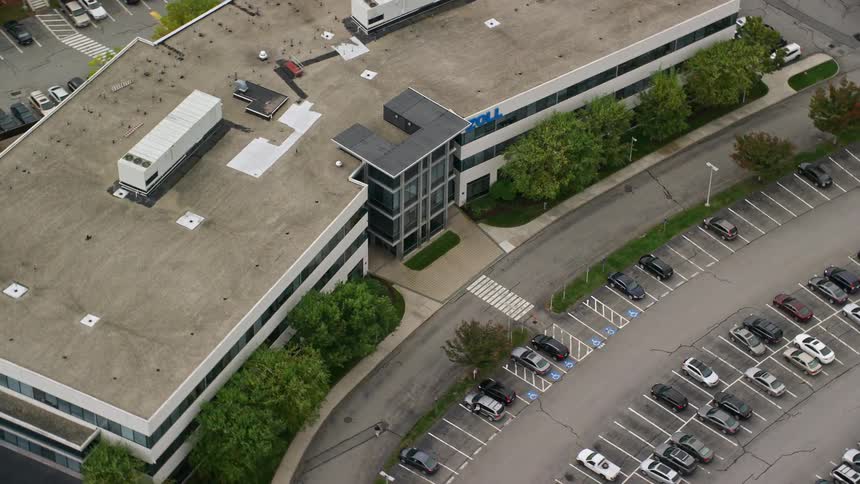 A business corporation building called zoll having a large car park surrounded with trees