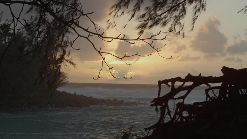 The water is rough near the shore at sunset