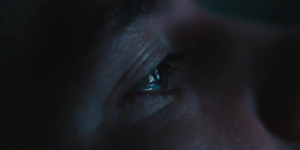 Persons eye reflects screen being viewed at night