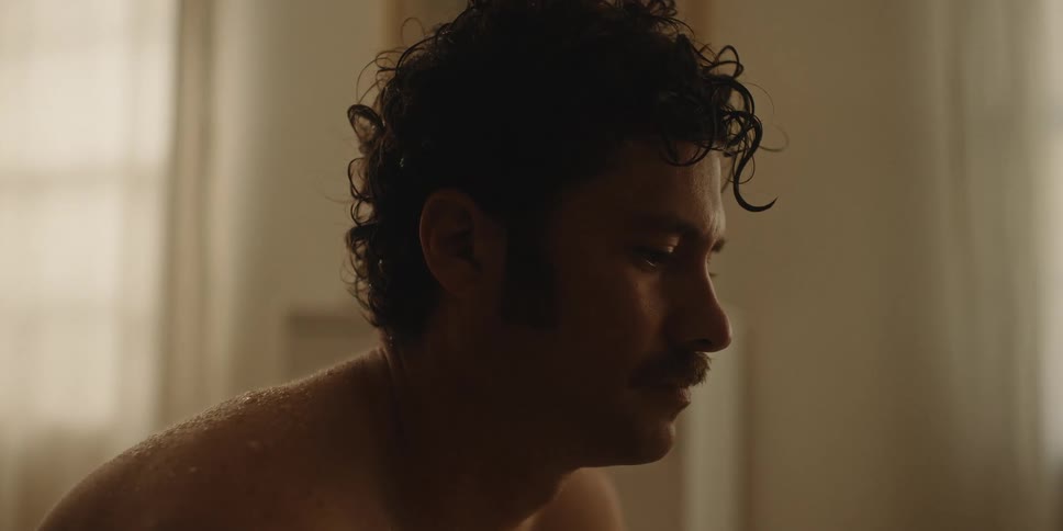 Man sitting on the bed with a sad facial expression