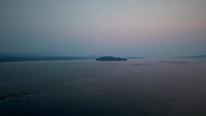 An island in the middle of the ocean at sunset