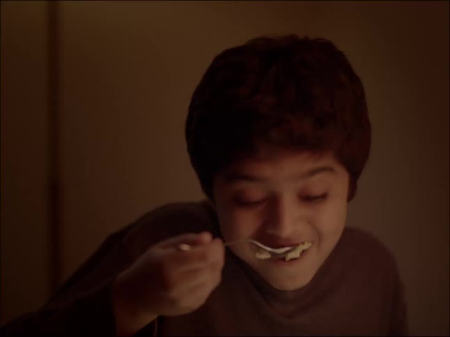 Portrait of a boy eating with a spoon