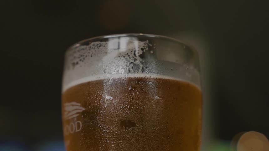 A glass of beer being caught in a persons hand