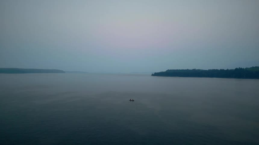 A boat sailing on the sea at sunset