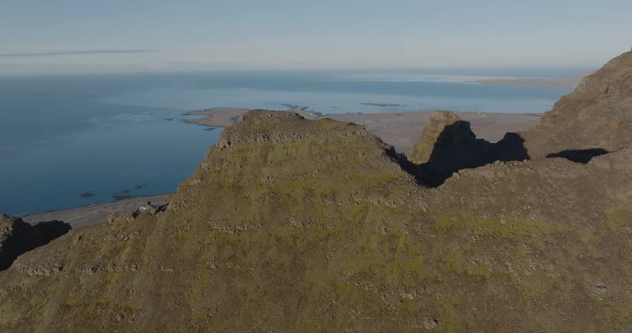 A very high mountain of rocks and at the base there is a connection with the sea