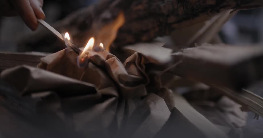 A person lights a fire