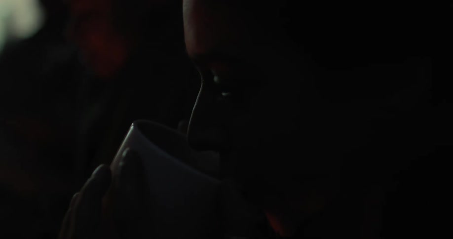 Woman blows on a steaming cup before drinking