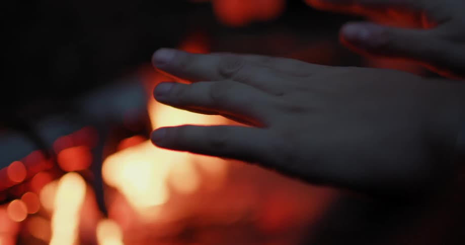 Person warming their hands over an open fire