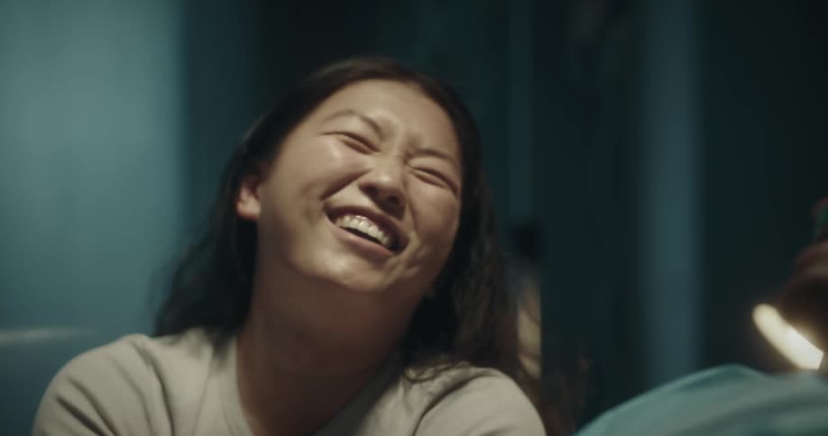 A woman is laughing and talking with a hospital patient