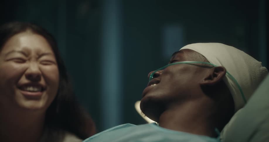 A woman talking to her partner who is lying on a hospital stretcher