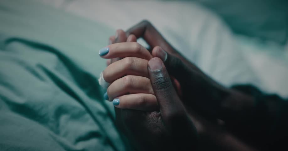 Closeup of the intertwined hands of a woman and a man