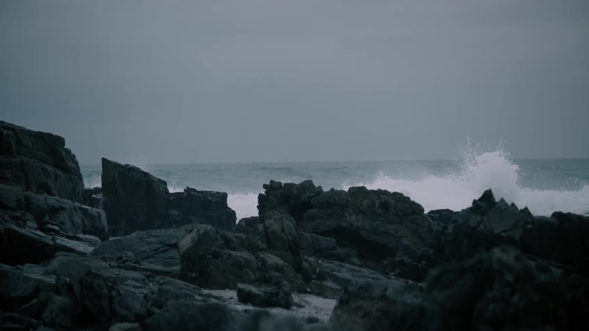 Rocky landscape around an ocean with waves crashing
