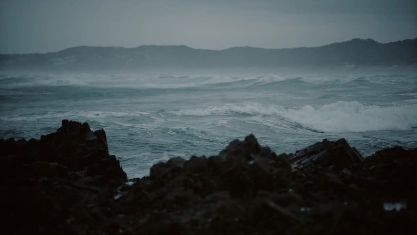 Waves crash against the shore on a stormy day