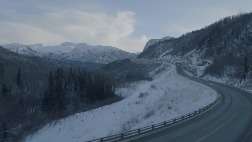 Pullback descent flying low over a mountain highway bridge deck