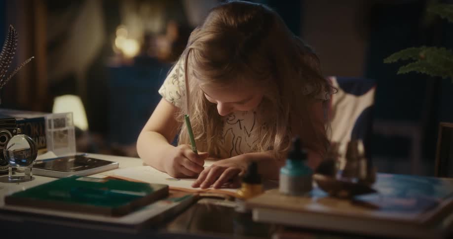 Girl sitting at a table in the living room drawing