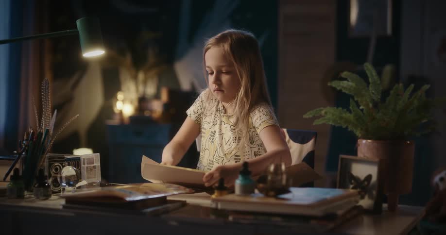 Girl places an envelope inside a folder at home
