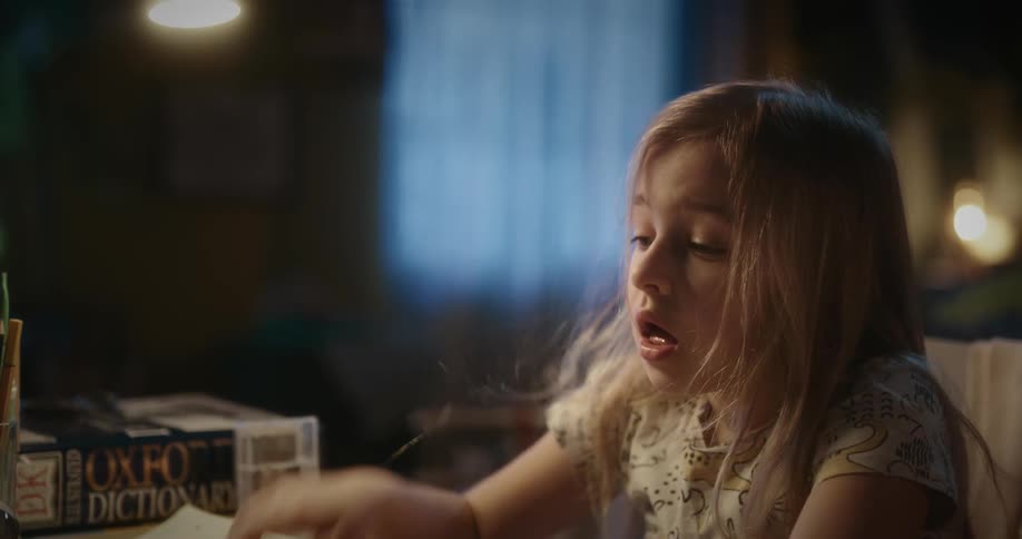 Female child looking tired while reading a text book indoor