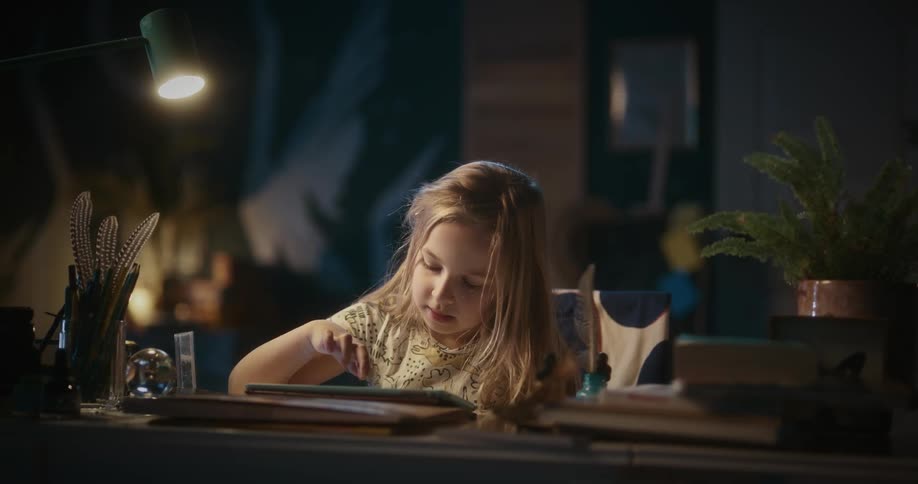 A girl at a table using a tablet