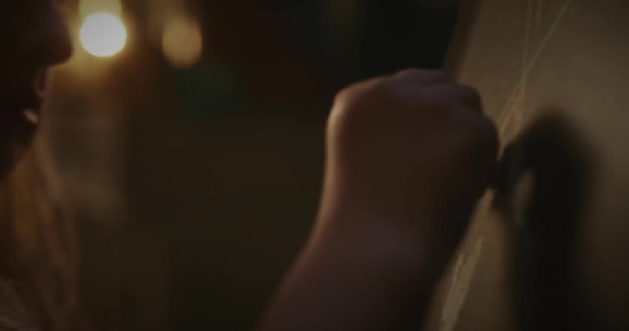 Closeup of a girl drawing on a chalkboard