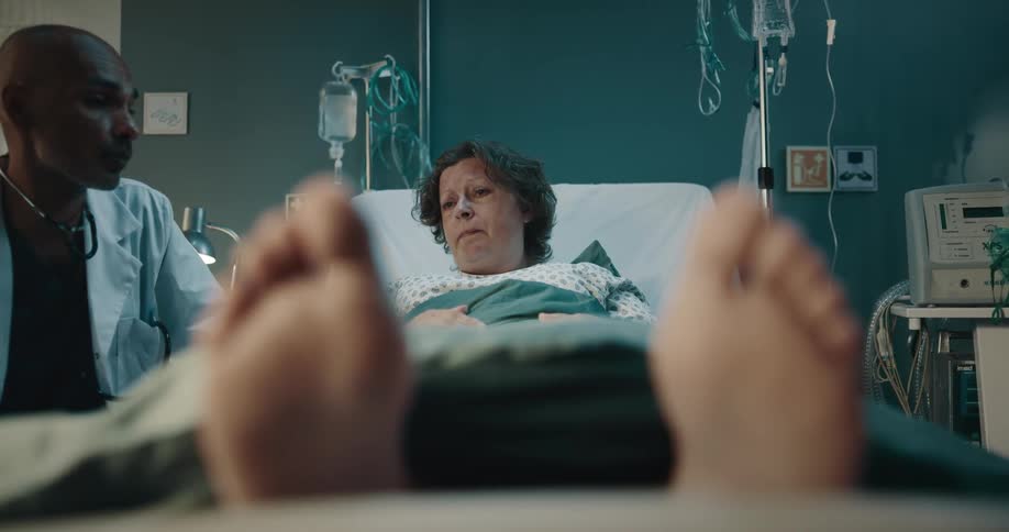 A woman lying in a hospital bed talking to a doctor and then he leaves