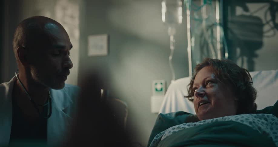 A woman on the sick bed receiving explanations from the male doctor