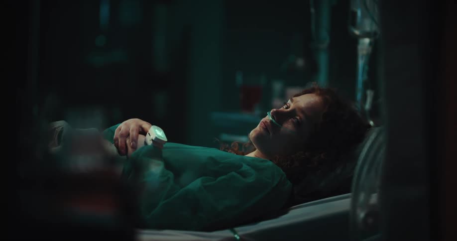 Lady lay on the hospital bed at night looking sad