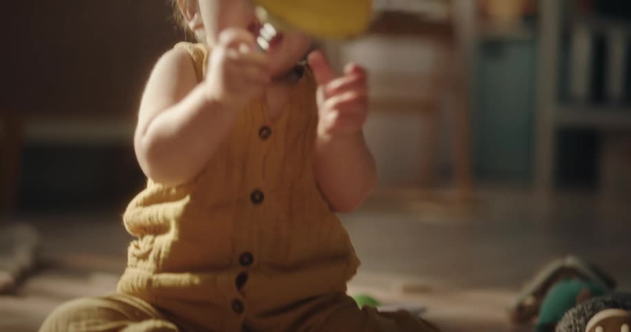 Toddler sits on floor and plays with toys