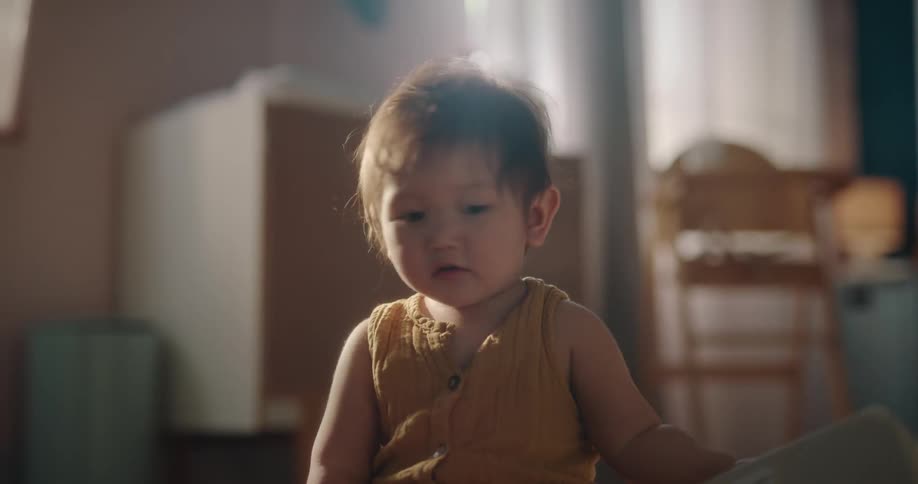 A baby crawling on the bedroom floor