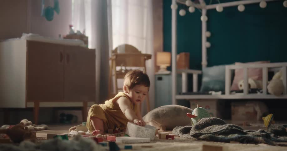 Young child plays alone while sitting on floor